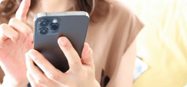 ペットシッターの依頼を考えている女性がスマホで問い合わせする様子